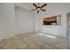 Living room with tile floors, ceiling fan, and pass-through window to the kitchen area at 6844 Tropicaire St, Las Vegas, NV 89149