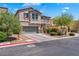 Stucco two-story home featuring desert landscaping, a two-car garage, and a charming tiled roof at 7194 Clear Range Ave, Las Vegas, NV 89178