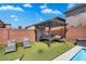 Backyard cabana featuring an outdoor sofa set, artificial grass, and lounge chairs at 7194 Clear Range Ave, Las Vegas, NV 89178