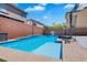 In-ground pool is surrounded by concrete, artificial grass, and privacy fencing at 7194 Clear Range Ave, Las Vegas, NV 89178
