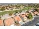 Expansive aerial view of a residential neighborhood bordering a golf course, showcasing well-maintained homes and landscaping at 7460 Desert Flame Ct, Las Vegas, NV 89149