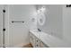 Modern vanity with black hardware, oval backlit mirror and quartz countertop at 7460 Desert Flame Ct, Las Vegas, NV 89149