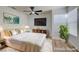 This bright bedroom is staged with a modern bed, television, and a neutral color scheme at 7460 Desert Flame Ct, Las Vegas, NV 89149