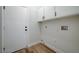 Mud room with wood-look floors, overhead cabinets for storage, and a utility hookup at 7460 Desert Flame Ct, Las Vegas, NV 89149