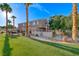 Back view of home with well-manicured lawn and a small gated patio area at 76 Stock Option St # 2, Henderson, NV 89074