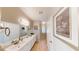 Bright bathroom boasts double sinks, large mirror, and modern fixtures at 76 Stock Option St # 2, Henderson, NV 89074