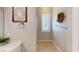Neutral-toned bathroom showcasing a window with shutters, tile flooring, and decorative wall hangings at 76 Stock Option St # 2, Henderson, NV 89074