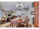 Well-lit dining area with a wooden table, chandelier, and view into the living area and kitchen at 76 Stock Option St # 2, Henderson, NV 89074