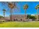 Townhouse exterior with a green lawn and palm trees in the front at 76 Stock Option St # 2, Henderson, NV 89074