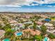 Expansive aerial view capturing the residential neighborhood, pools, landscaping, and the distant cityscape and mountains at 7730 Brambly Creek Ct, Las Vegas, NV 89129