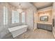 Bright bathroom features a soaking tub with modern chandelier and a single vanity at 7730 Brambly Creek Ct, Las Vegas, NV 89129