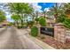 A gated entrance to Hobble Creek Estates with lush landscaping and decorative stone pillars at 7730 Brambly Creek Ct, Las Vegas, NV 89129
