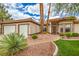 Inviting front of home featuring desert landscaping, a two-car garage, and a quaint walkway to the front door at 7730 Brambly Creek Ct, Las Vegas, NV 89129