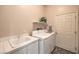 Well-equipped laundry room with sink, storage and modern washer and dryer units at 7730 Brambly Creek Ct, Las Vegas, NV 89129