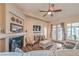 Bright living room featuring a fireplace, ceiling fan, and doors leading to the backyard at 7730 Brambly Creek Ct, Las Vegas, NV 89129
