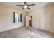 Comfortable bedroom features carpet flooring, ceiling fan, natural lighting, and access to the ensuite bathroom and closet at 7730 Brambly Creek Ct, Las Vegas, NV 89129