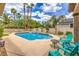 A beautiful pool area with palm trees, desert plants, and comfortable seating, perfect for outdoor enjoyment at 7730 Brambly Creek Ct, Las Vegas, NV 89129