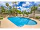 A refreshing pool with a step-down entrance, surrounded by palm trees and desert plants, ideal for relaxation at 7730 Brambly Creek Ct, Las Vegas, NV 89129