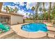 View of a private backyard oasis with a pool, tropical palms and turquoise chairs; ideal for outdoor relaxation at 7730 Brambly Creek Ct, Las Vegas, NV 89129