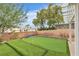 Backyard features synthetic grass and putting green creating a low-maintenance outdoor entertainment space at 7929 Ben Hogan Dr, Las Vegas, NV 89149
