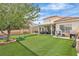 Expansive backyard featuring a covered patio, lush artificial grass, and ample room for recreation at 7929 Ben Hogan Dr, Las Vegas, NV 89149