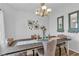 Dining room with a wooden table, upholstered chairs, chandelier, and decorative wall mirrors at 7929 Ben Hogan Dr, Las Vegas, NV 89149