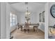 Elegant dining room with a chandelier, decor, hardwood floors, and natural light from the window at 7929 Ben Hogan Dr, Las Vegas, NV 89149