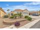 Inviting single-story home with desert landscaping, featuring rocks, bushes, and a two-car garage at 7929 Ben Hogan Dr, Las Vegas, NV 89149