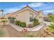 Charming single-story home with desert landscaping featuring rocks, flowers, bushes, and a two-car garage at 7929 Ben Hogan Dr, Las Vegas, NV 89149