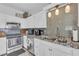 Bright kitchen boasts white cabinetry, granite countertops, stainless steel appliances and modern backsplash at 7929 Ben Hogan Dr, Las Vegas, NV 89149
