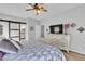 Spacious main bedroom featuring dresser, decorative lamps, ceiling fan and ensuite bath at 7929 Ben Hogan Dr, Las Vegas, NV 89149