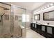 Modern bathroom featuring double sinks, and a separate walk-in shower with glass doors at 852 Colina Alta Pl, Las Vegas, NV 89138
