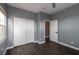 This bedroom has gray walls, dark wood floors, closet with sliding doors, and a window at 852 Colina Alta Pl, Las Vegas, NV 89138