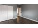 Bedroom with gray walls, dark wood floors, closet with sliding doors, and white trim at 852 Colina Alta Pl, Las Vegas, NV 89138