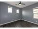 Bedroom featuring dark floors, gray walls, a ceiling fan, and three large windows at 852 Colina Alta Pl, Las Vegas, NV 89138