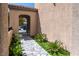 Arched entrance featuring desert landscaping, a stone walkway and a wrought iron gate at 852 Colina Alta Pl, Las Vegas, NV 89138