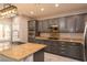 Well-equipped kitchen with gray cabinets, stainless steel appliances, and a granite-topped island at 852 Colina Alta Pl, Las Vegas, NV 89138
