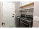 Laundry room with new front load washer and dryer and storage shelves above at 852 Colina Alta Pl, Las Vegas, NV 89138