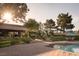 An amazing backyard with a pool, patio area with table and chairs, and plenty of green foliage at 8620 W La Madre Way, Las Vegas, NV 89149