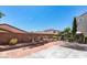 Backyard featuring a brick and concrete patio with retaining wall and privacy fence at 9856 Chief Sky St, Las Vegas, NV 89178