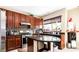 Well-lit kitchen featuring dark wood cabinetry, stainless steel appliances, and a convenient kitchen island with marble countertop at 9856 Chief Sky St, Las Vegas, NV 89178