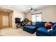 Spacious living room offers a comfortable blue sectional, a ceiling fan, and a large screen TV for relaxing at 9856 Chief Sky St, Las Vegas, NV 89178
