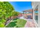 Entertainer's backyard featuring a covered patio, pavers, manicured lawn, BBQ, and water feature at 10025 San Floriano St, Las Vegas, NV 89178