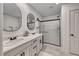 Bathroom featuring dual sinks, large mirrors, and a glass enclosed shower at 10025 San Floriano St, Las Vegas, NV 89178
