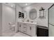 Bathroom featuring dual sinks, large mirrors, and a glass enclosed shower at 10025 San Floriano St, Las Vegas, NV 89178