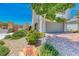 Close up exterior featuring a stone yard and a two-car garage surrounded by greenery at 10025 San Floriano St, Las Vegas, NV 89178