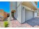 Front entrance with brick-paved walkway, leading to a front door and an attached garage at 10025 San Floriano St, Las Vegas, NV 89178