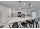 Bright kitchen features an island with barstool seating, light grey cabinets, and modern pendant lighting at 10025 San Floriano St, Las Vegas, NV 89178