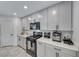 Close up of modern kitchen featuring stainless steel appliances, white cabinets, and granite countertops at 10025 San Floriano St, Las Vegas, NV 89178