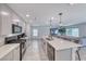 Modern kitchen features a large island with seating, stainless steel appliances, and tile floors at 10025 San Floriano St, Las Vegas, NV 89178